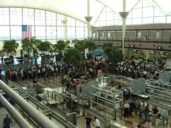TSA Officer operate a security line at an airport