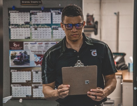 A warehouse manager checks a clipboard.