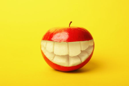picture of a red apple with a smile carved into it