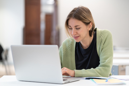 woman working on her laptop taking online college classes