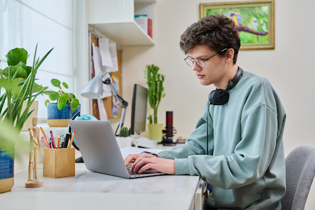 young man doing school work on his laptop - best free online colleges in Mississippi