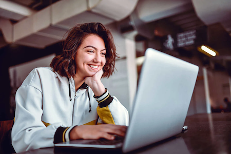 Young woman taking online classes on her laptop computer